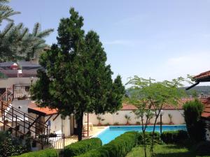 a swimming pool in the middle of a yard with trees at Family Hotel Accent in Razgrad