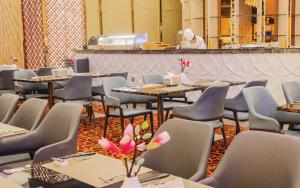 a dining room with tables and chairs and a chef at Wisney Hotel in Sihanoukville