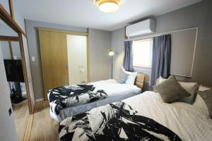 a hotel room with two beds and a window at Yukimi Nakafurano in Nakafurano