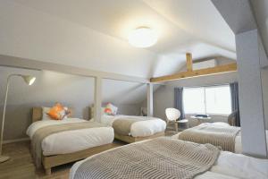 a bedroom with two beds and a window in it at Yukimi Nakafurano in Nakafurano +34 photos