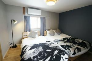 a bedroom with a black and white bed with a window at Yukimi Nakafurano in Nakafurano