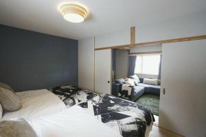 a bedroom with a bed and a living room at Yukimi Nakafurano in Nakafurano