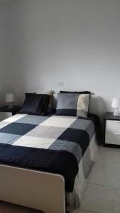 1 dormitorio con 1 cama grande con sábanas azules y blancas en Sun Beach 5, en Caleta de Fuste
