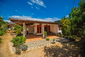 a small white house with a porch at Enu Homestay in Dickwella