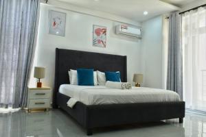 a bedroom with a large bed with blue pillows at Aqua Azuri apartment in Mombasa