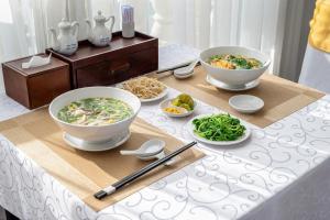 a table with bowls and plates of food on it at Tao Dan Hotel in Ho Chi Minh City