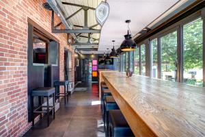 a long wooden bar in a room with windows at RAVeL Hotel Cyrano in Waimes