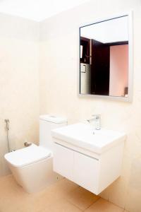a white bathroom with a sink and a mirror at Samaya Waters Bentota in Haburugala