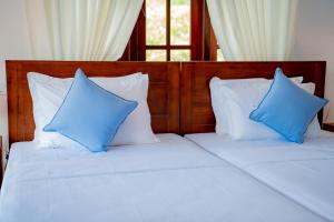a bed with blue and white pillows on it at Samaya Waters Bentota in Haburugala