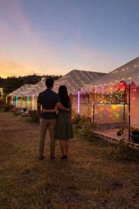 a man and a woman standing in front of a tent at Aura Resort and Restaurant in Chikalthān