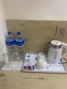 a counter with a coffee maker and two bottles of water at Hotel Indrawoti and Resort in Dhulikhel