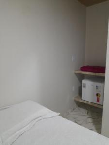 a bedroom with a bed and a microwave on a shelf at Pousada-Suítes Alto do Moura in Caruaru +21 photos