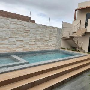 a swimming pool in front of a brick wall at Pousada-Suítes Alto do Moura in Caruaru