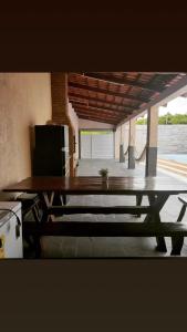 a wooden picnic table in a room with a patio at Pousada-Suítes Alto do Moura in Caruaru