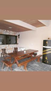 a dining room with a wooden table and benches at Pousada-Suítes Alto do Moura in Caruaru