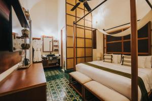 ein Hotelzimmer mit Bett und Schreibtisch in der Unterkunft CIGNO Mejorada Hotel Boutique in Mérida