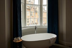 
a white bath tub sitting next to a window at Bristol Harbour Hotel & Spa in Bristol
