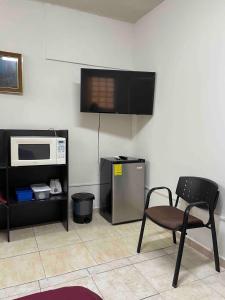 a kitchen with a microwave and a chair in a room at Loft 1 with 2 beds near Fundidora and Cintermex in Monterrey