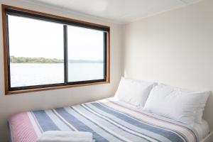 a bedroom with a bed and a window at Waterscape Floating Apartment in Augusta