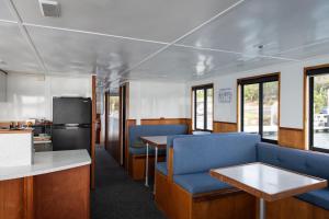 a train car with blue chairs and a table at Waterscape Floating Apartment in Augusta