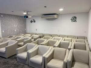 an empty room with white chairs and a wall at Hotel Mais Lazer - Hotel & Spa in Joinville +46 photos
