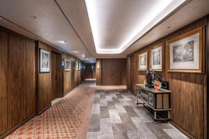 a hallway with wood paneling and a table in a building at Orange Crystal Hotel Yantai Binhai Square in Yantai