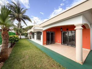 a house with orange walls and a green lawn at Diego Bay Villa in Antsiranana