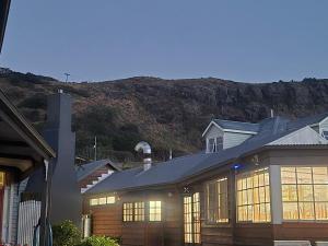 a house with windows and a mountain in the background at Angel's Aisle Cottages & Cafe in Stanley