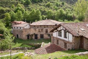 una vieja casa de piedra en medio de un campo en Posada de Urreci, en Aldeanueva de Cameros