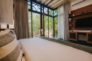 ein Schlafzimmer mit einem großen Bett und einem großen Fenster in der Unterkunft CIGNO Mejorada Hotel Boutique in Mérida + 40 Fotos