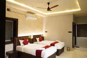 a hotel room with two beds with red pillows at Sova Premium in Jagatsinghapur