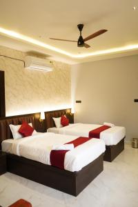 a hotel room with two beds with red pillows at Sova Premium in Jagatsinghapur +2 photos