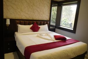 a bedroom with a large bed with red and white pillows at Sova Premium in Jagatsinghapur