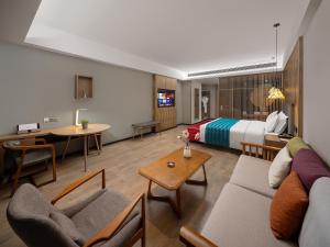 a hotel room with a bed and a living room at 复美酒店 in Luoyang