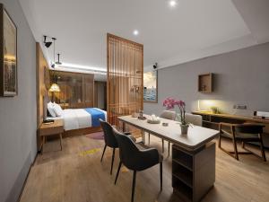 a hotel room with a bed and a table and chairs at 复美酒店 in Luoyang