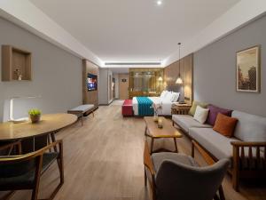 a hotel room with a couch and a bed at 复美酒店 in Luoyang