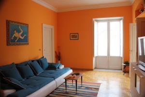 パレルモにあるLa Loggia del Marcheseのオレンジ色の壁のリビングルーム(青いソファ付)