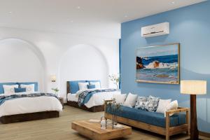 a bedroom with two beds and a blue wall at Hotel SHOL Ninh Chu in Thôn Nhơn Sơn