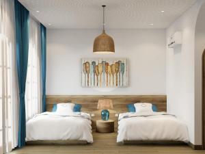 a bedroom with two beds and a lamp at Hotel SHOL Ninh Chu in Thôn Nhơn Sơn