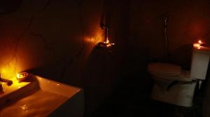 a dark bathroom with a toilet and a sink at Farm Shaala in Tiruttani +36 photos