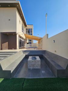 a large building with a bench in front of it at TiDise Villas & Chalets إستراحة وشاليه تايدايس in Bimmah