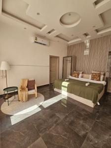 a bedroom with a large bed and a chair at TiDise Villas & Chalets إستراحة وشاليه تايدايس in Bimmah +6 photos