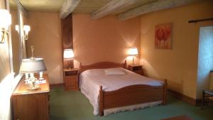 a bedroom with a bed and a table and lamps at Les Vergnes in Saint-Pardoux-le-Neuf +40 photos