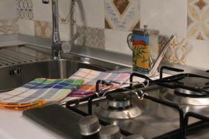 - un évier de cuisine avec une cuisinière et 2 serviettes dans l'établissement A Casa di Turiddu, à Scicli