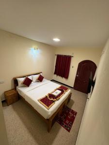 a bedroom with a large bed with red pillows at The Hill Bunk Heights Ooty in Ooty
