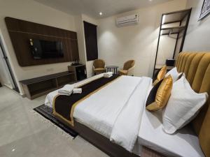 a bedroom with a large bed and a television at HOTEL AYUSHMAN in Varanasi
