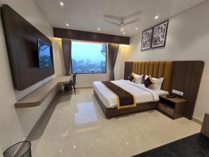 a bedroom with a large bed and a large window at HOTEL AYUSHMAN in Varanasi