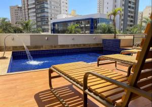 a balcony with two benches and a swimming pool at St Oeste Superking Ar, Cozinha, Office, Vaga in Goiânia