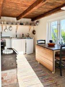 a kitchen with a wooden table and a counter top at Rural Guest House Between Simrishamn And Skillinge in Simrishamn