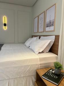 a bedroom with a large white bed and a table at St Oeste Superking Ar, Cozinha, Office, Vaga in Goiânia +17 photos